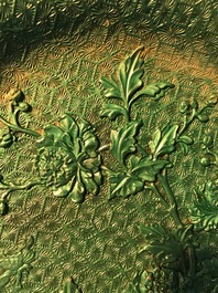 Een Chinees groen lakwerk bord met floraal decor, 19/20e eeuw